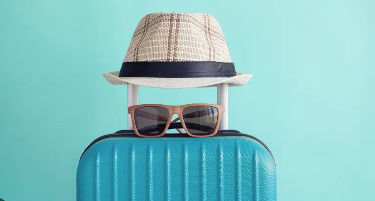 Suitcase with hat and sunglasses ready for a Miami day