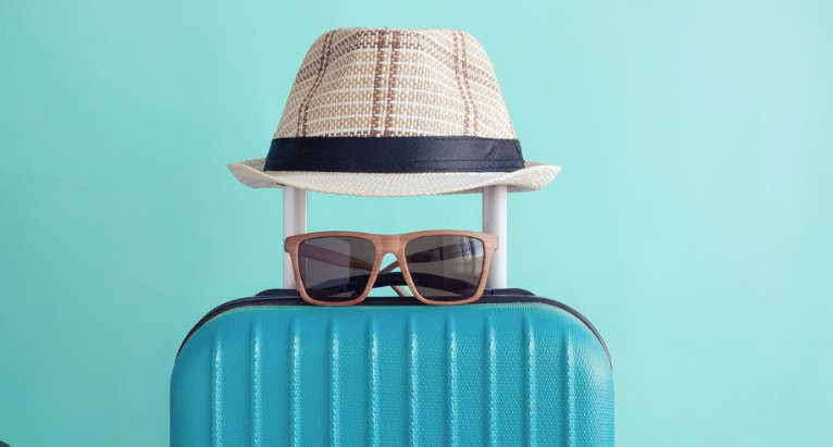Suitcase with hat and sunglasses ready for a Miami day
